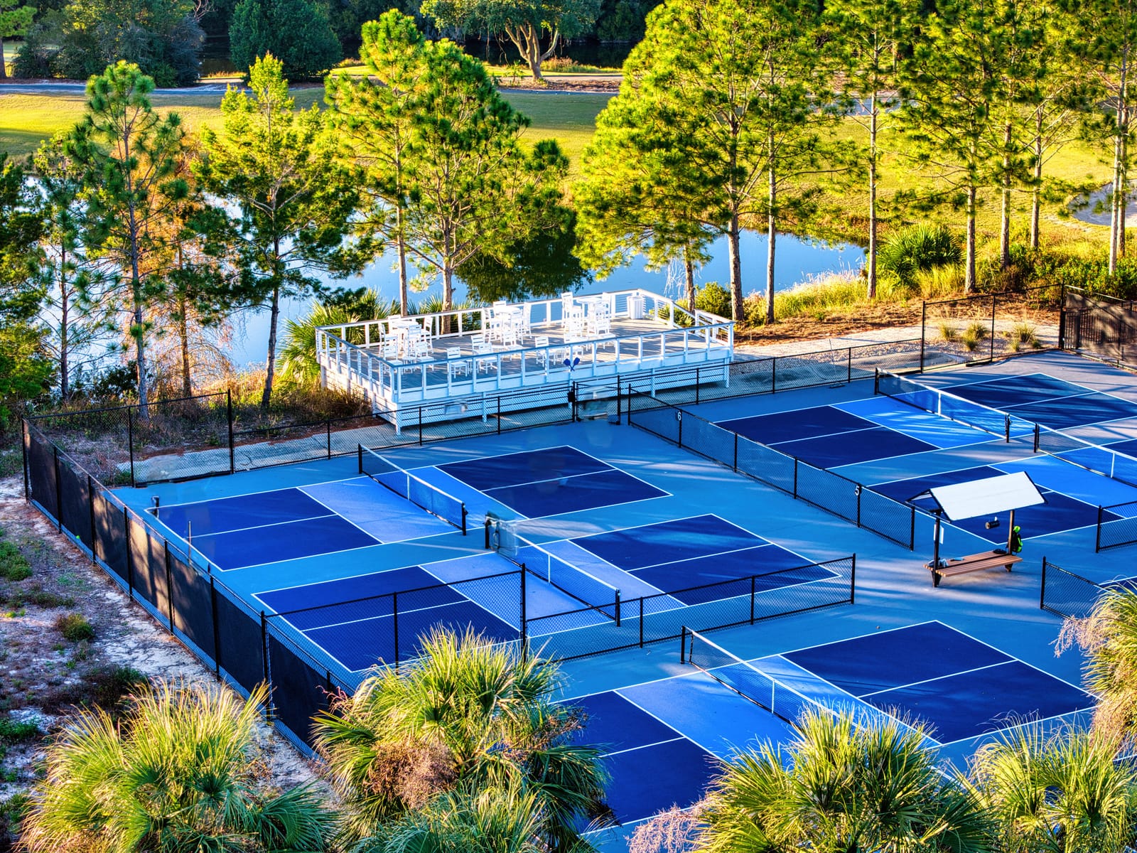 Aerial view of the eight pickleball courts and lakeside viewing deck at St. James Bay in Carrabelle, Florida